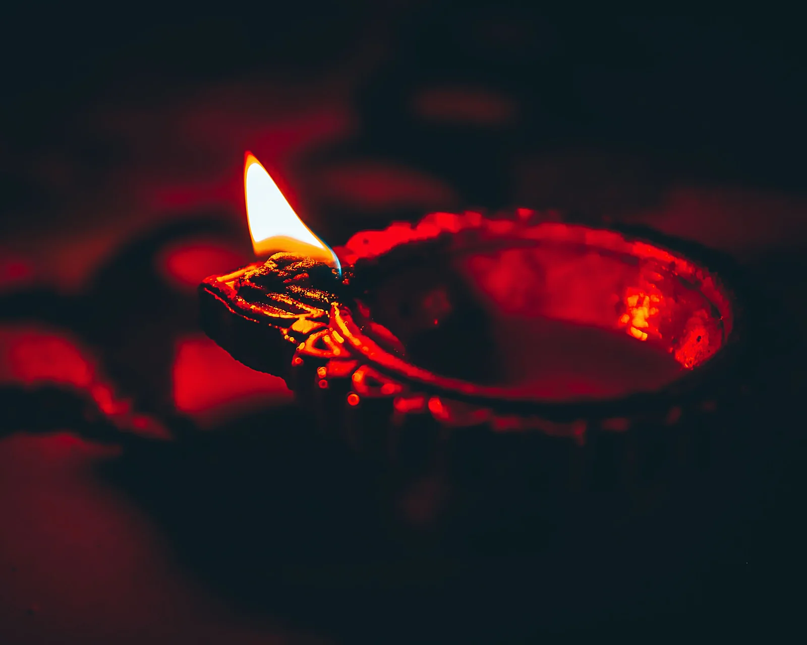 Fiamma rituale accesa in una lampada votiva rossa